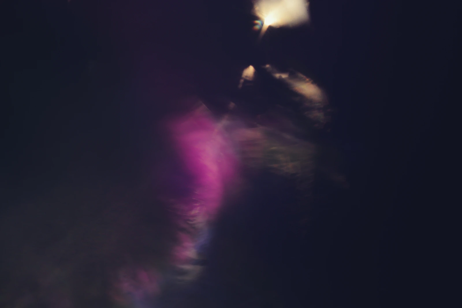 Fond sombre abstrait traversé de volutes de fumée colorées